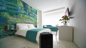A hotel room with a bed, a desk, a chair, a potted plant, and a large painting on the wall. - Becoloured Water Lily Suite. Where it is possible to dream among the masterpieces of art. (Napoli)