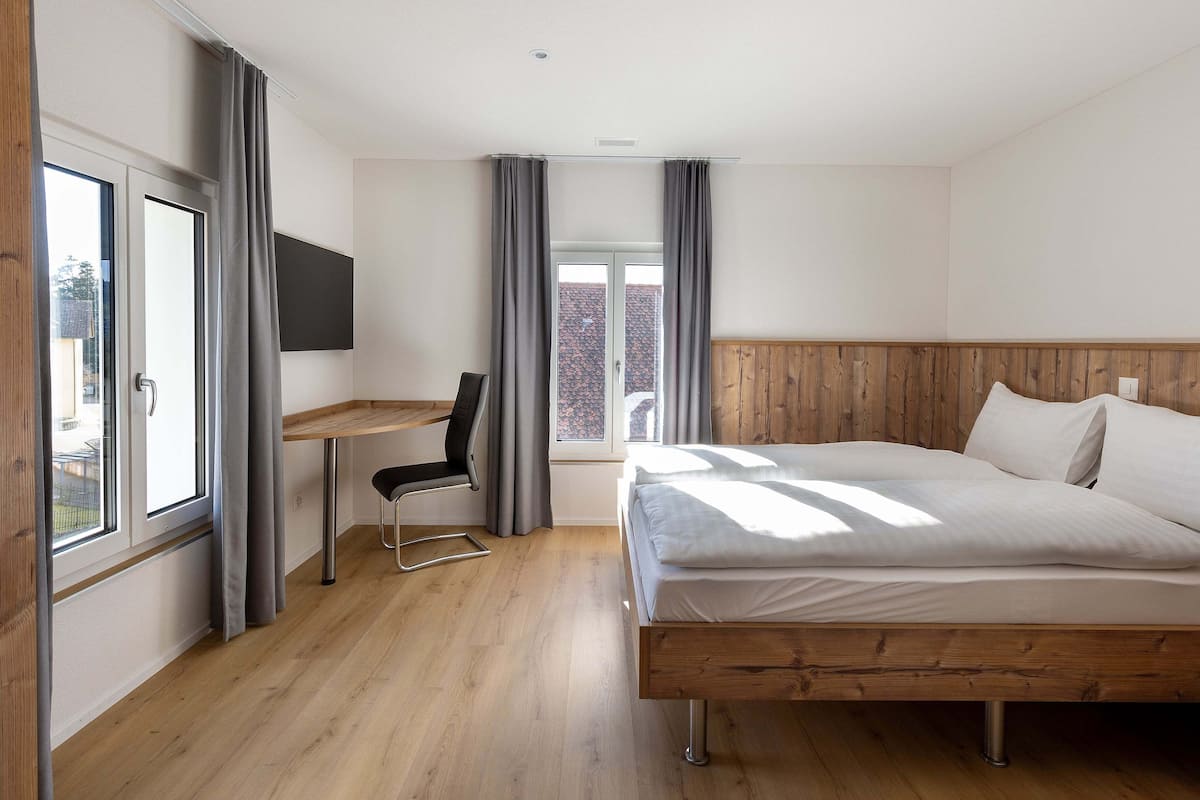 A bedroom with a wooden bed, a desk, and a chair.