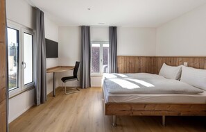 Un dormitorio con una cama de madera, un escritorio y una silla.