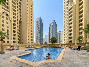 A swimming pool surrounded by high-rise residential buildings.