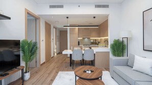 A modern apartment with a living room, dining area, and kitchen.