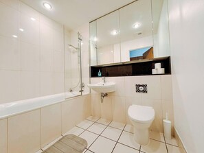 A modern bathroom with a bathtub, a sink, a toilet, and a shower. - Londonaprt/sleeps6/gym/waterfront/wifi (London)