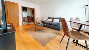 A modern living room with a sofa, coffee table, and dining area. - Londonaprt/sleeps6/gym/waterfront/wifi (London)