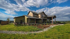 A two-story house with a covered porch and a view of the surrounding landscape. - New Custom Home on 35 Acres - Amazing Mtn Views -15 Min to DGO - AC/Hot Tub (Durango)
