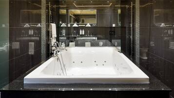 A modern bathroom with a large bathtub, a glass-enclosed shower, and a vanity with a mirror.