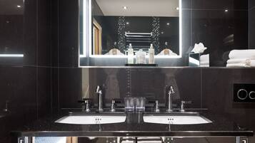 Un baño moderno con dos lavamanos, un espejo grande y un perchero para toallas.