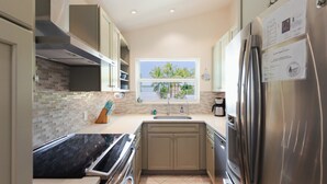 Una cocina moderna con ventana, electrodomésticos de acero inoxidable y salpicadero de azulejos.