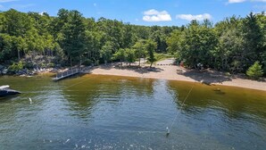 A serene lakeside setting with a wooden dock extending into the water, surrounded by dense forest. - Unusual Latitude Limit 7 3 Bedroom Villa (Raymond)