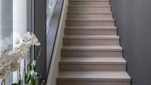 A modern staircase with a glass railing, leading to a room with a large window and a green wall feature. - Villa Luxor With Heated Pool (Malinska-Dubasnica)