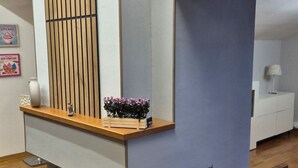 Moderni sisustus, jossa on puinen tiski, peili ja pieni kasvi.