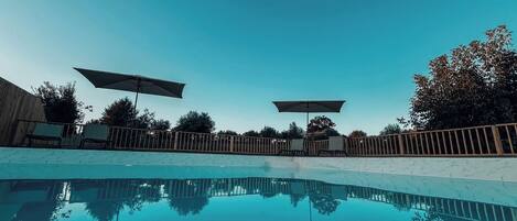 Piscine extérieure, parasols de plage, chaises longues