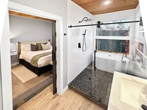 Quarto com cama, mesa de cabeceira e janela.