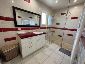 Een douche, handdoeken, zeep, toiletpapier