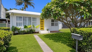 Una casa residencial amb un jardí ben cuidat, un camí que porta a la porta principal i una bústia.