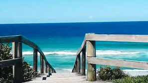 A wooden staircase leading to a beach with ocean views. - Frangipani Hideaway - Close to everything! (Budgewoi)