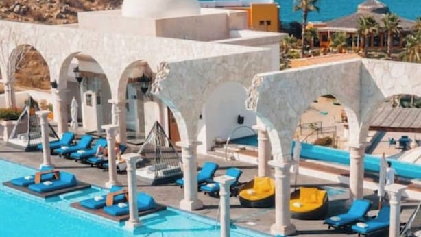 Un espace piscine avec des chaises longues et une vue sur la mer.