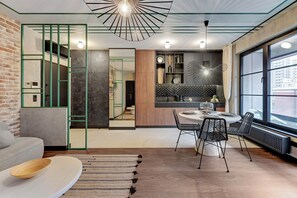 Una cocina moderna con comedor, que incluye una mesa redonda, sillas negras y vistas amplias a través de grandes ventanales.
