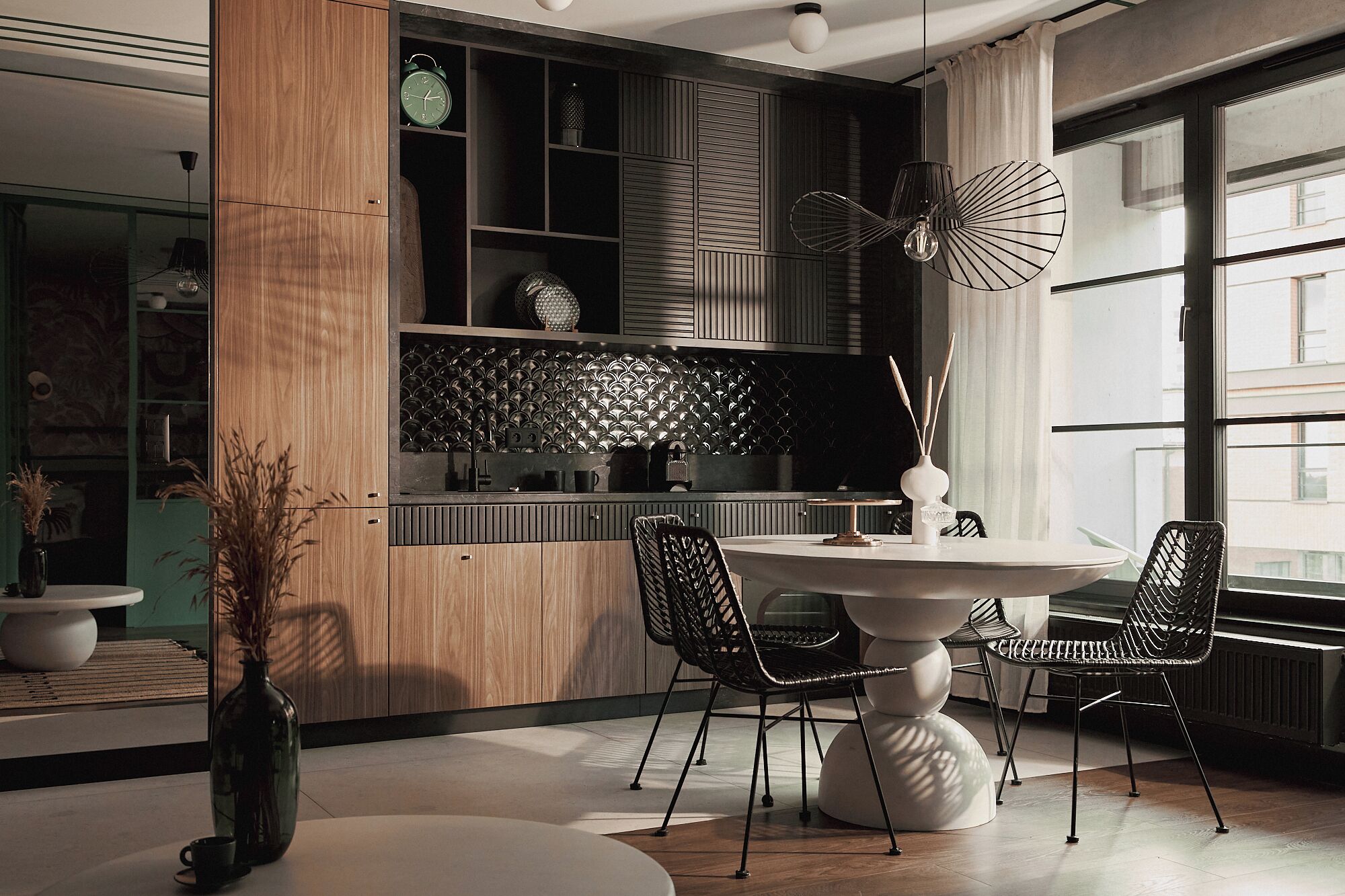Un comedor moderno con una mesa redonda, sillas negras y un abanico decorativo.