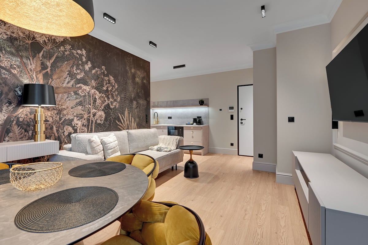 Ein modernes Wohnzimmer mit Essbereich, einer Couch, einem Couchtisch und einem großen Wandbild.