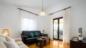 A modern living room with a sofa, a coffee table, and a TV on a stand. - Graceful Apartment With Barbecue Area (Porec)