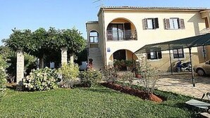 A two-story building with a flat roof and a balcony on the upper floor. - Graceful Apartment With Barbecue Area (Porec)