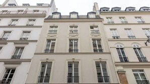 Eine Reihe mehrstöckiger Gebäude mit einheitlichem Baustil, mit Balkonen und großen Fenstern.