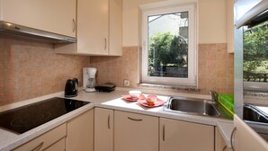 A compact kitchen with a window, a coffee maker, and a sink. - Graceful Apartment in Nature (Porec)