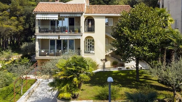 A two-story house with a balcony, surrounded by greenery and trees. - Graceful Apartment in Nature (Porec)