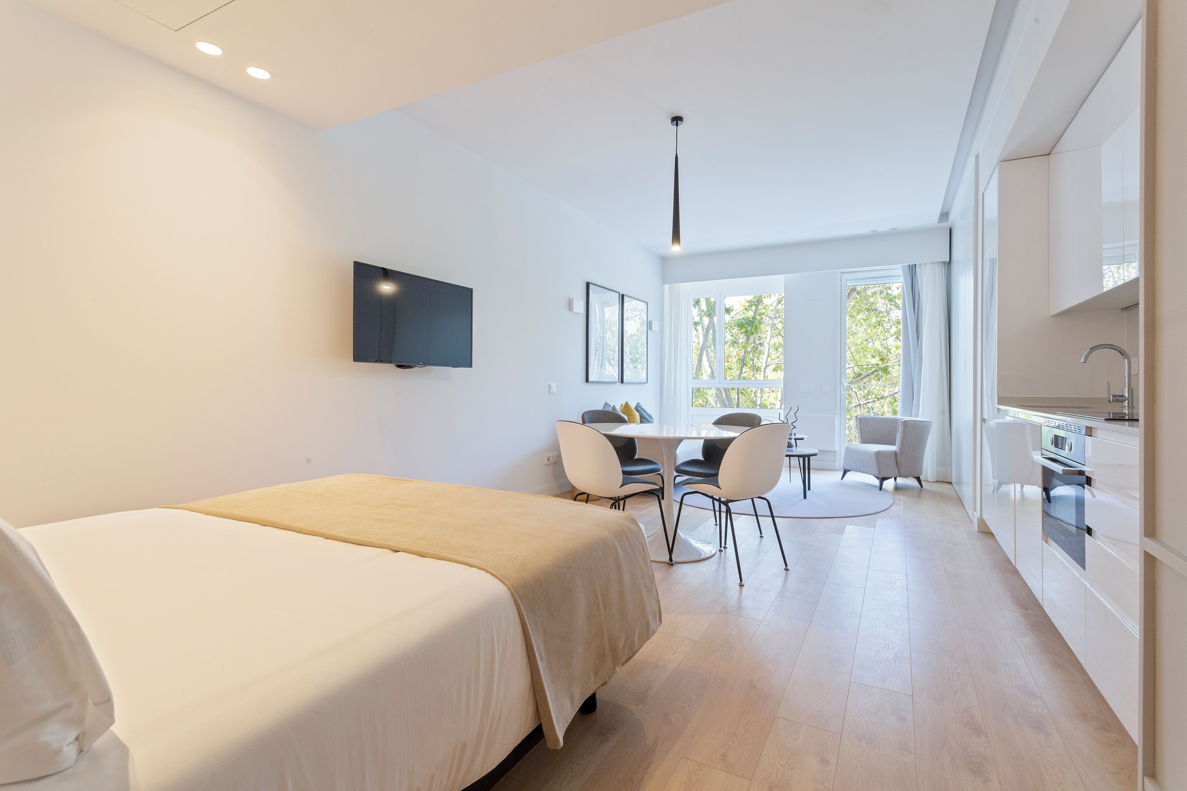 Une chambre d’hôtel moderne dotée d’un grand lit, d’un coin repas et d’une cuisine.