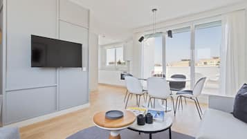 Dúplex Deluxe, vista a la ciudad | Área de sala de estar | Televisión de pantalla plana