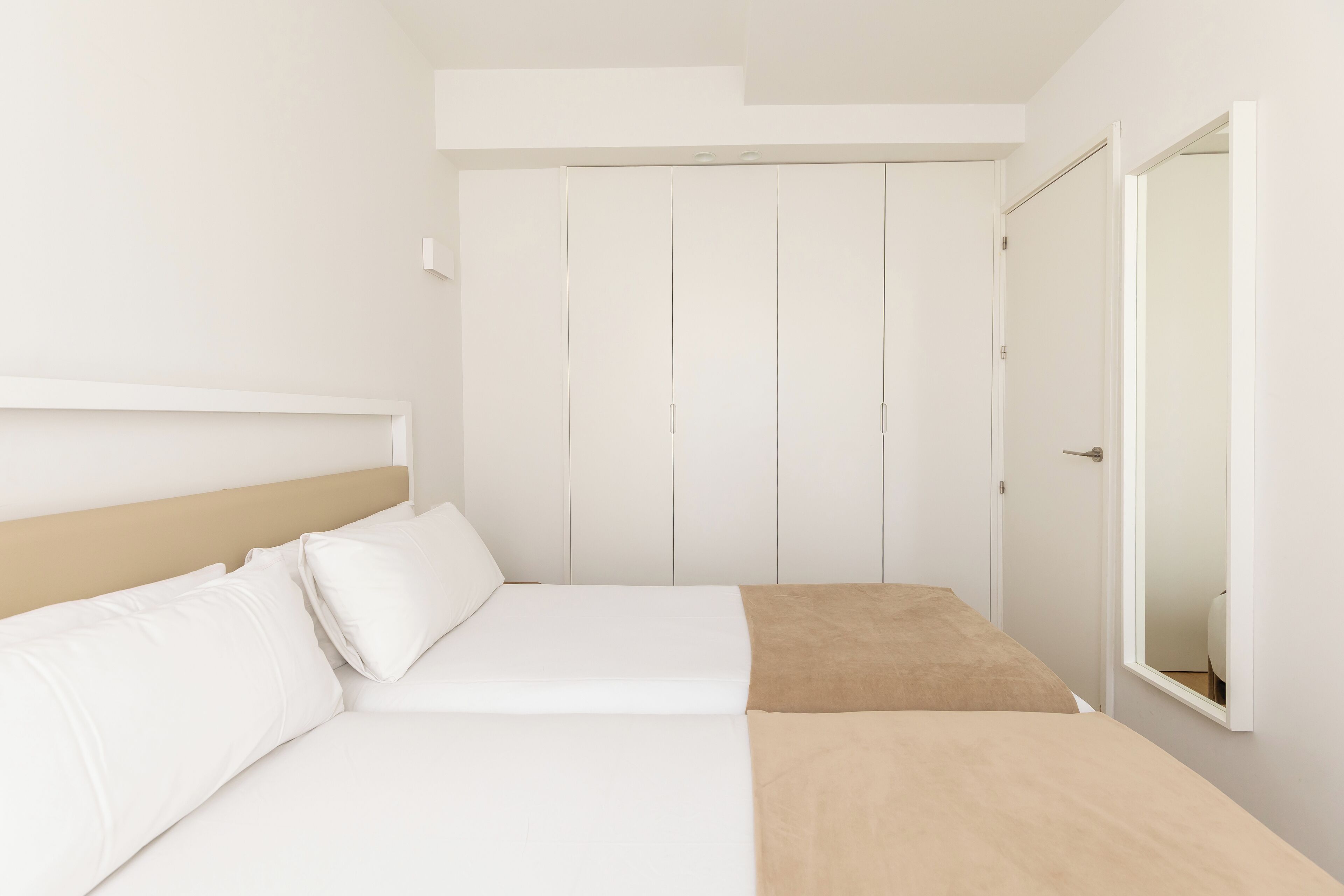 Une chambre à coucher avec un lit, une armoire et un miroir.