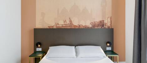 A hotel room with a bed, two bedside tables, a headboard, and a cityscape wall art.