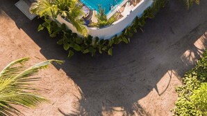 A resort with a swimming pool surrounded by palm trees and a building with a green roof. - Kondey Villas (Kondey)