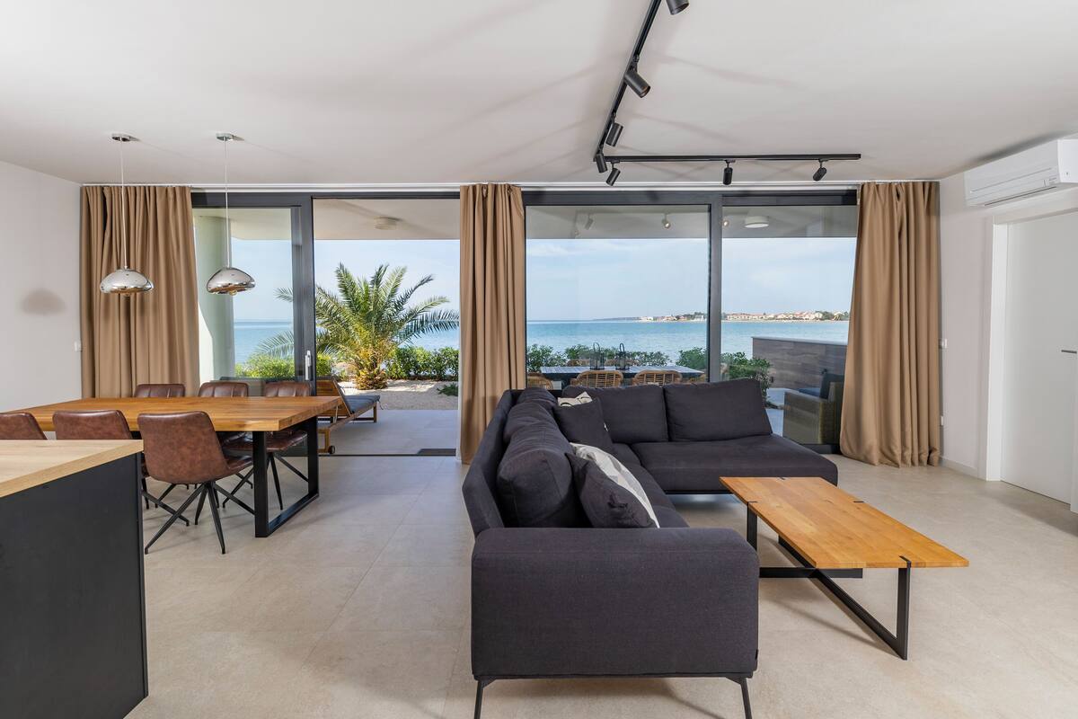 Un salon moderne avec un canapé, une table en bois et un coin repas avec des chaises.