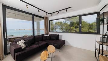 Condo, balcón, vista al mar | Área de sala de estar | Televisión LCD de 55 pulgadas con canales vía satélite y Netflix