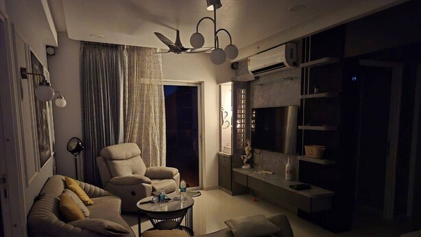Una sala de estar con sofá, sillón y mesa de centro. Hay un televisor y una chimenea.