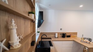 Eine moderne Küche mit Holzsäulen, einer schwarzen Arbeitsplatte und einer eingebauten Spüle.