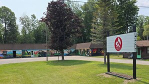 A grassy area with a fire hydrant sign, a mural, and a building with a green door.