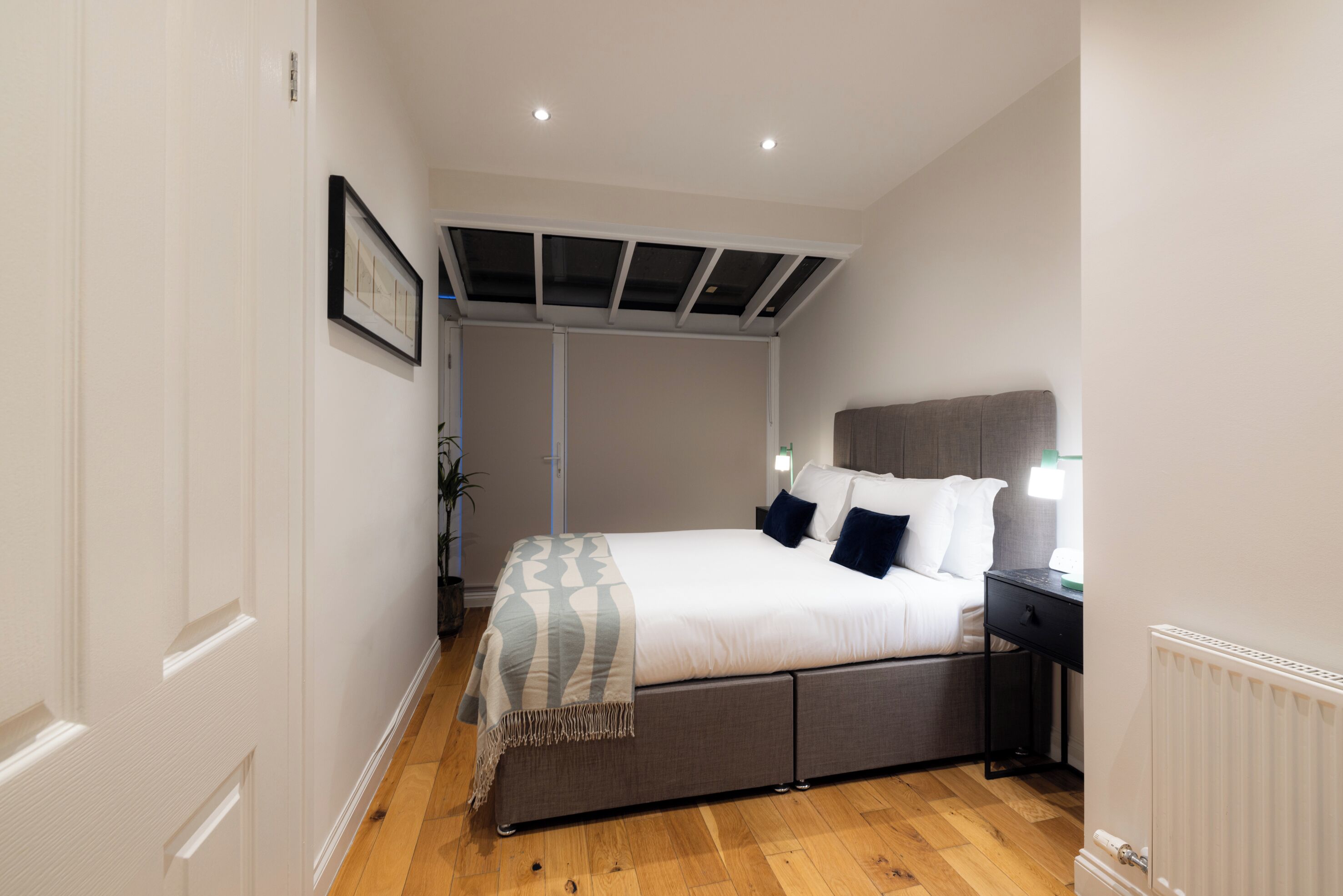 A bedroom with a bed, bedside table, and a radiator.