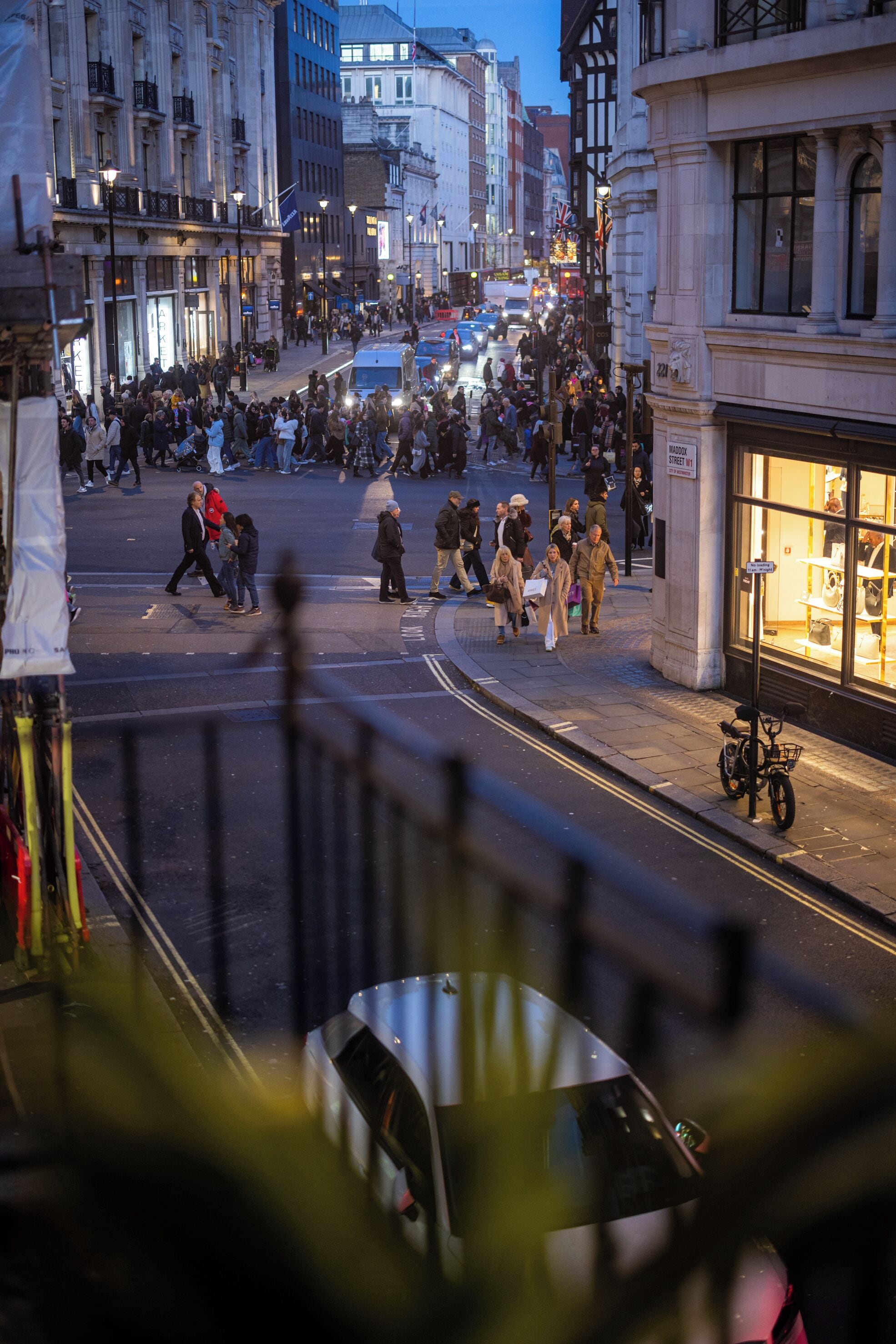 A busy urban street scene with pedestrians and vehicles.