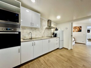 Comfort Townhome | Private kitchen | Full-size fridge, microwave, oven, stovetop