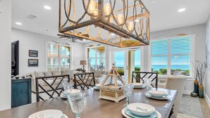 Un coin repas avec une table en bois, dressée pour quatre personnes, entourée de chaises.