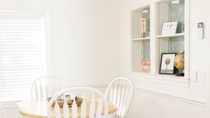 A dining area with a white table and chairs, a ceiling fan, and a window with decorative items. - Remodeled 3 bed, 2 bath in Cowpens, SC. Near Gaffney, Spartanburg, Charlotte (Cowpens)