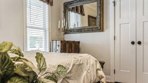A bedroom with a bed, a large mirror, a wardrobe, and a window with blinds. - Beautiful Historic DT Raleigh (Raleigh)