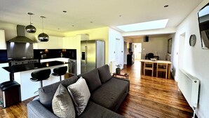 Una cocina moderna con estufa integrada, refrigerador y taburetes de bar.