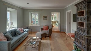A spacious living room with a grey sofa, a wooden coffee table, and a patterned cabinet. - New top-equipped vacation apartment - 20m to the lake in historic monastery fiefdom (Tegernsee)