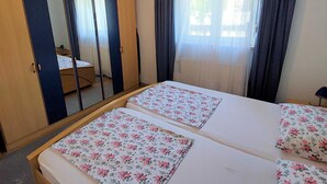 A bedroom with two beds, a large mirror, a wardrobe, and a window with curtains. - Cozy Retreats in Crikvenica Quiet Neighborhood (Crikvenica)