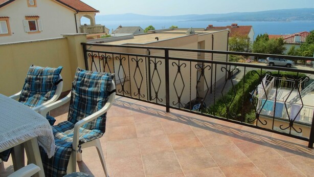 A balcony with two chairs and a table, overlooking a sea and distant mountains. - Cozy Retreats in Crikvenica Quiet Neighborhood (Crikvenica)