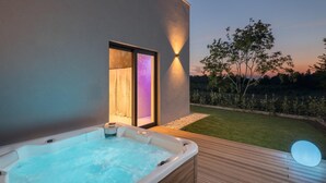 A hot tub on a wooden deck with a view of a garden and a sunset. - Luxury Villa in Tar With View (Tar-Vabriga)