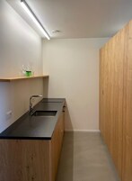 A modern kitchen with a black countertop, wooden cabinets, and a built-in sink.
